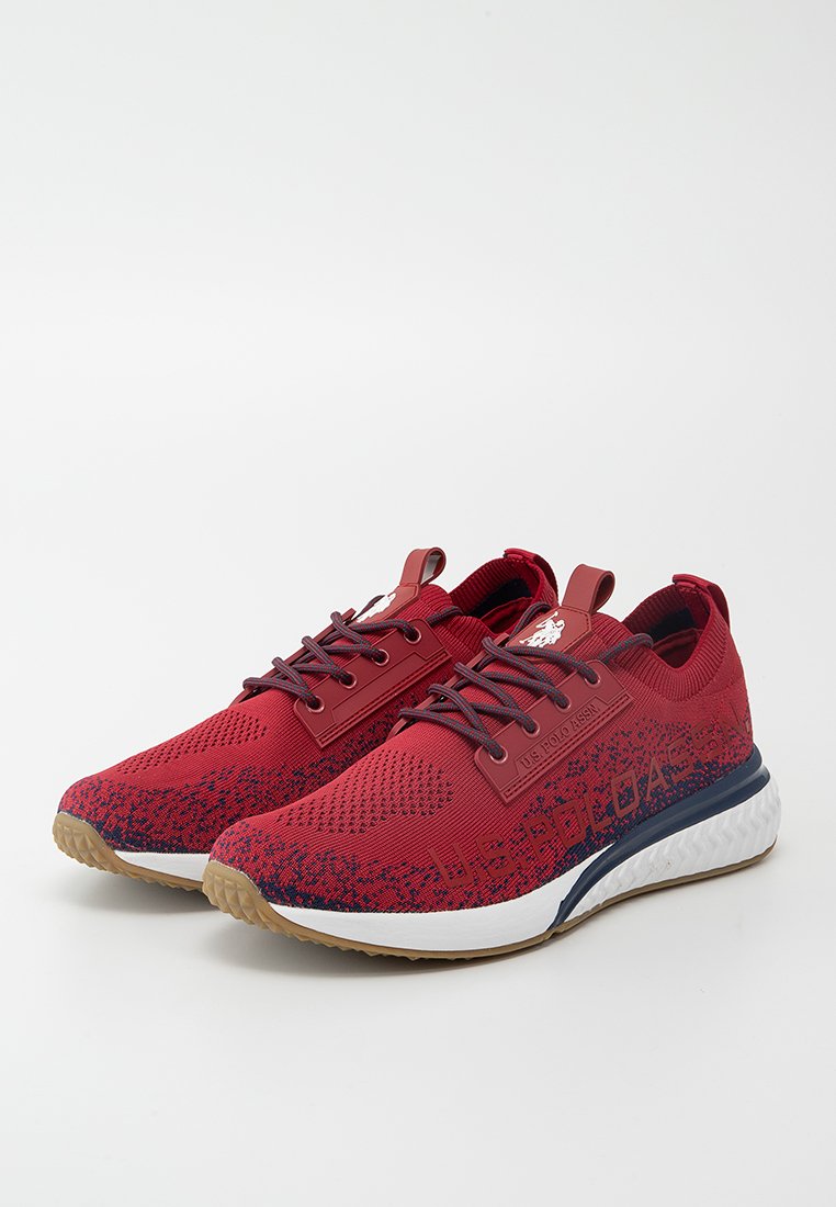 Baskets de sport en tricot rouge avec un dessus texturé, accents navy et semelle intermédiaire blanche. Elles disposent de lacets réglables et de détails à motifs.