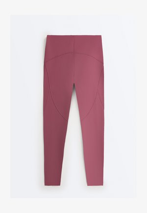 Legice z visokim pasom v barvi maline z ukrivljenimi šivi, prikazane na ravni površini na belem ozadju.