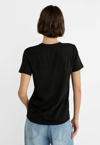 T-shirt en coton noir à manches courtes et encolure ronde. Présente un design uni, une texture douce et une coupe décontractée.
