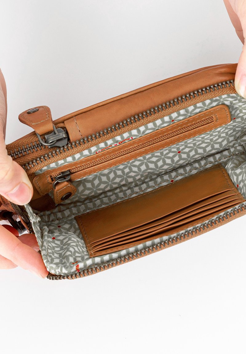 Braune Lederbrieftasche mit Reißverschluss, ausgestattet mit einem grauen gemusterten Innenfutter, mehreren Kartenfächern und einem Reißverschlussfach für Münzen.