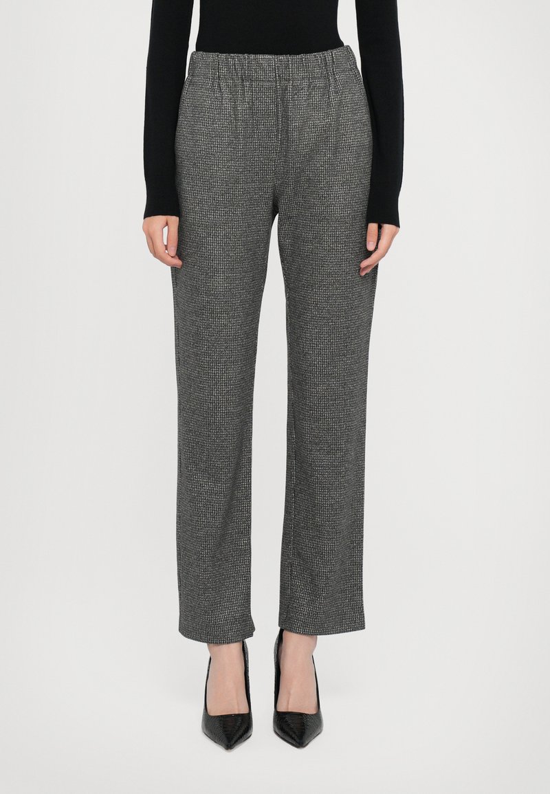 Grau karierte Hose mit einem elastischen Bund, geradem Bein und weichem Material, kombiniert mit schwarzen spitzen Absatzschuhen.