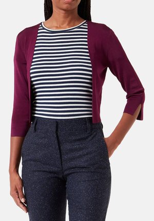 Burgundy cardigan with three-quarter sleeves over a navy and white striped top, paired with dark, textured pants featuring a subtle pattern.