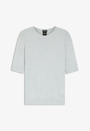 Vaaleanharmaa lyhythihainen pyöreäkauluksinen neulepaita, jossa on resorireunukset hihoissa ja helmassa, esillä makuulla ja musta merkkilappu näkyvissä kaula-aukon kohdalla.