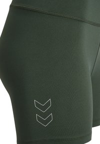 Dunkelgrüne Sportshorts aus einem glatten, dehnbaren Material. Weißes Chevron-Logodetail in der Nähe des Saums, mit Flachnaht für Komfort.