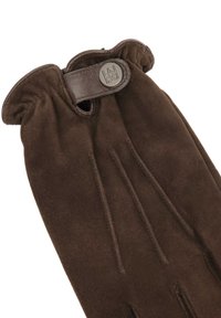 Guante de ante marrón con muñeca fruncida, que cuenta con una correa de cuero y un acento de botón. Textura suave con cuatro costuras en los dedos para mayor estructura.