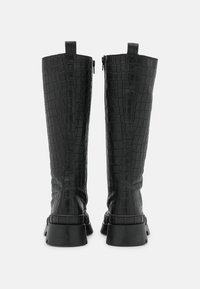 Bottes montantes noires en cuir embossé façon crocodile avec une finition texturée, fermeture éclair au dos et semelles en caoutchouc épaisses pour une meilleure adhérence.