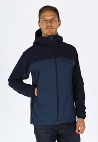 Mørkeblå jakke med hætte, kontrasterende øverste panel, frontlynlås og sidelommer. Fremstillet af letvægts, vandafvisende materiale.