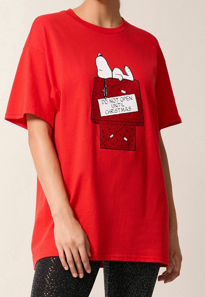 Červené bavlněné tričko s grafikou Snoopy na dárkové krabičce a textem "NEOTVÍREJ PŘED VÁNOCI", krátké rukávy a pohodlný střih.