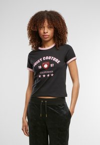 Černé tričko s krátkým rukávem, růžovým límečkem a manžetami, s nápisem a logem "Juicy Couture" v bílé a růžové barvě, zdobené hvězdami.