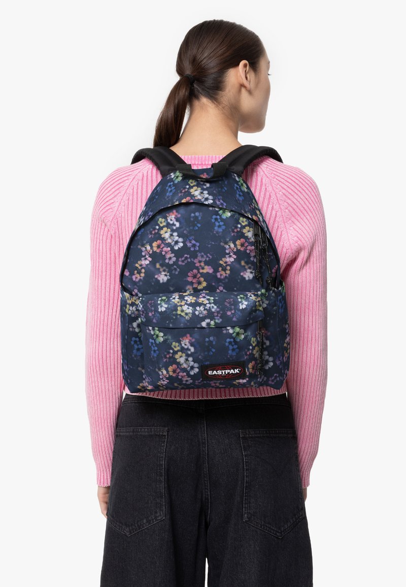 Zaino a fiori in blu navy, realizzato in tessuto resistente. Presenta spallacci neri regolabili e una tasca frontale con logo.