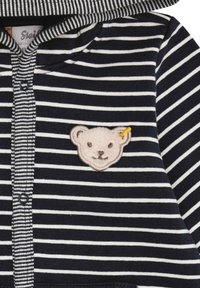 Gestreifter Baumwoll-Hoodie in Marineblau und Weiß, mit einem Bärenkopf-Patch auf der Brust und einer Knopfleiste mit kontrastierendem Blenden.