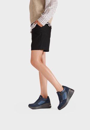 Sneakers blu navy con una combinazione di materiali lisci e testurizzati, caratterizzati da una suola a zeppa, chiusura con lacci e dettaglio con zip laterale.