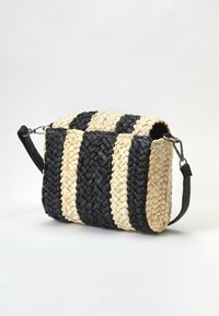 Borsa intrecciata con strisce nere e naturali di paglia, forma rettangolare, apertura superiore, manico corto nero e dettagli in metallo argentato.