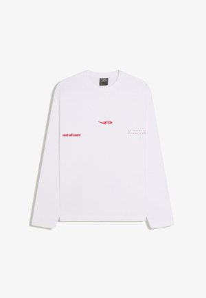 Biele tričko s dlhým rukávom s červeným textom „out of core“ na ľavej strane a „uniqueness for everyone“ na pravej strane, plus červené logo s vírivým motívom v strede.