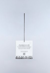 Tag hanging by black string with text about 100% responsibly grown cotton and Napapijri brand name at the bottom.