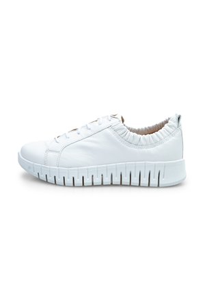 White leather sneaker featuring a stretchy, ruched collar, round toe, and a thick, ridged sole with cutouts for ventilation.