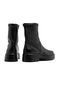 Schwarze Knöchelstiefel aus strukturiertem Leder, mit einem glatten Schaft, einer robusten Profilsohle und einem seitlichen Reißverschluss für einen einfachen Zugang.