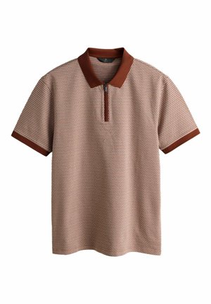 Īsām piedurknēm polo krekls no strukturēta bēša auduma, ar rūsas sarkanā krāsā apkakli un rāvējslēdzēja kakla izgriezumu. Vienkāršs dizains ar ģeometrisku rakstu.