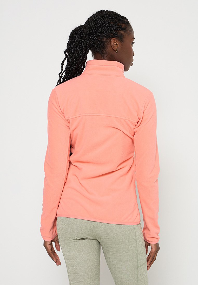 Chaqueta de forro polar en color rosa coral, con un cuello alto y mangas largas. Textura suave con una costura en la parte superior de la espalda.