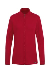 Giacca rossa con zip realizzata in tessuto morbido, dotata di maniche lunghe, colletto alto e due tasche laterali. Sottile bordo con logo lungo la zip.