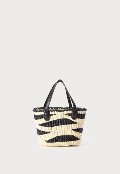 Petit sac en osier tissé avec un motif zigzag noir et naturel et des poignées en cuir noir sur un fond blanc.