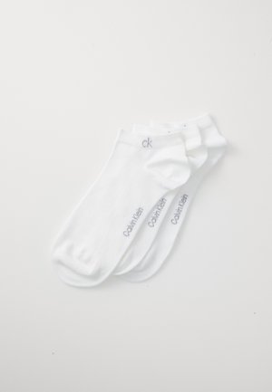 Meias de algodão brancas para o tornozelo com punhos canelados; apresentam o logotipo cinza "Calvin Klein" de lado; três pares empilhados.