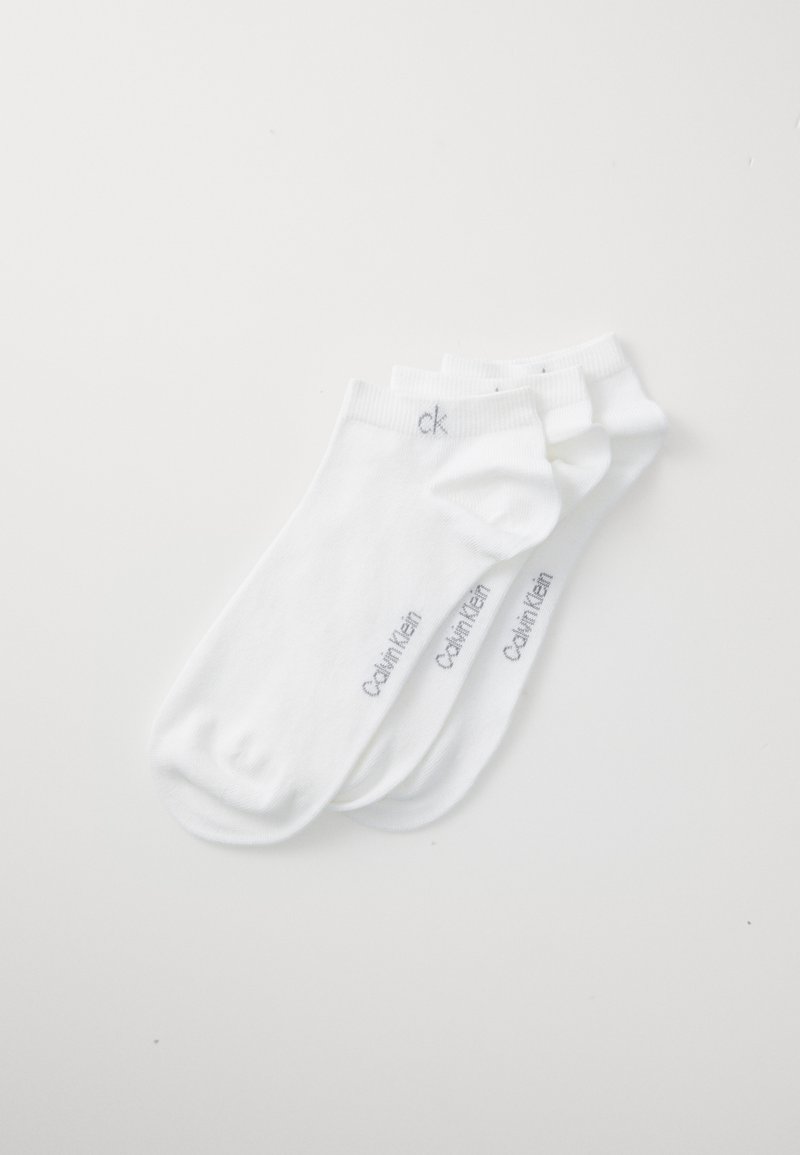 Fehér pamut bokazoknik bordázott gumival; a sideján szürke "Calvin Klein" logóval; három pár egymásra rakva.