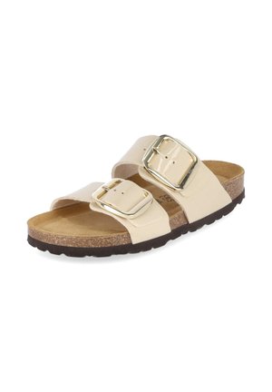 Beige Slipper-Sandale mit zwei breiten Riemen mit großen goldenen Schnallen, Korkfußbett und schwarzer profilierter Sohle.