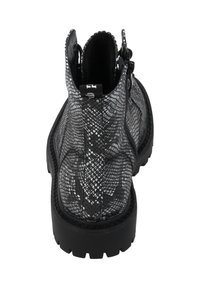 Stivaletti alla caviglia con motivo pelle di serpente in bianco e nero, suola spessa a tasselli, cerniera laterale e linguetta sul retro.
