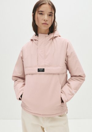 Light pink pullover jacket with a hood, featuring a front pocket and black branding. Made of smooth, water-resistant material.