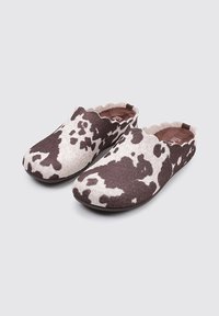 Zuecos de fieltro con un patrón de vaca en marrón y blanco, con punta redondeada, superficie texturizada y borde superior ondulado para un diseño de fácil uso.