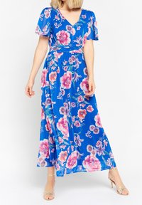 Květinové maxi šaty v modré barvě, s krátkými volánkovými rukávy, výstřihem do V a vzory růžových a fialových květin. Hladká, lehká látka, délka sahající až na kotníky.