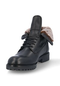 Botín de cuero negro hasta el tobillo con diseño de cordones, cuello forrado de pelo y suela de goma texturizada con tacos prominentes.