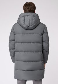 Grå pufferjakke med hætte, der har horisontalt quiltede sektioner, to sidelommer og en glat, vandafvisende tekstil.
