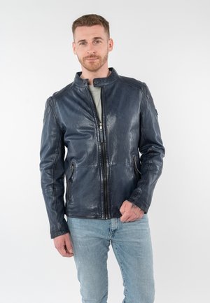 Giacca in pelle blu navy con collo alla coreana, chiusura frontale con cerniera e due tasche laterali. Tessitura liscia con cuciture visibili e dettagli sulle spalle.