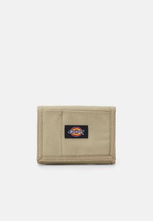 Beige stofpung med et foldet design. Har et sort Dickies-logo-patch på forsiden, med synlige sydetaljer.