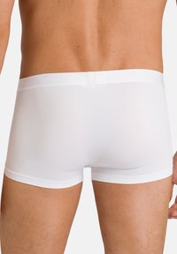 White men's boxer briefs made from stretchy fabric, featuring a soft waistband with the brand name, smooth texture, and fitted design.
