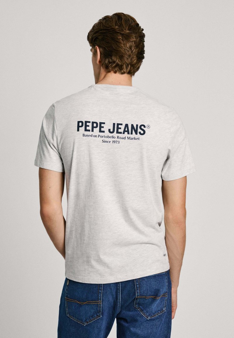 Pelēka kokvilnas t-krekls ar apaļu kakla izgriezumu un īsām piedurknēm. Aizmugurē ir jūras zilā krāsā "PEPE JEANS" logo un teksts. Klasiska piegriezuma.