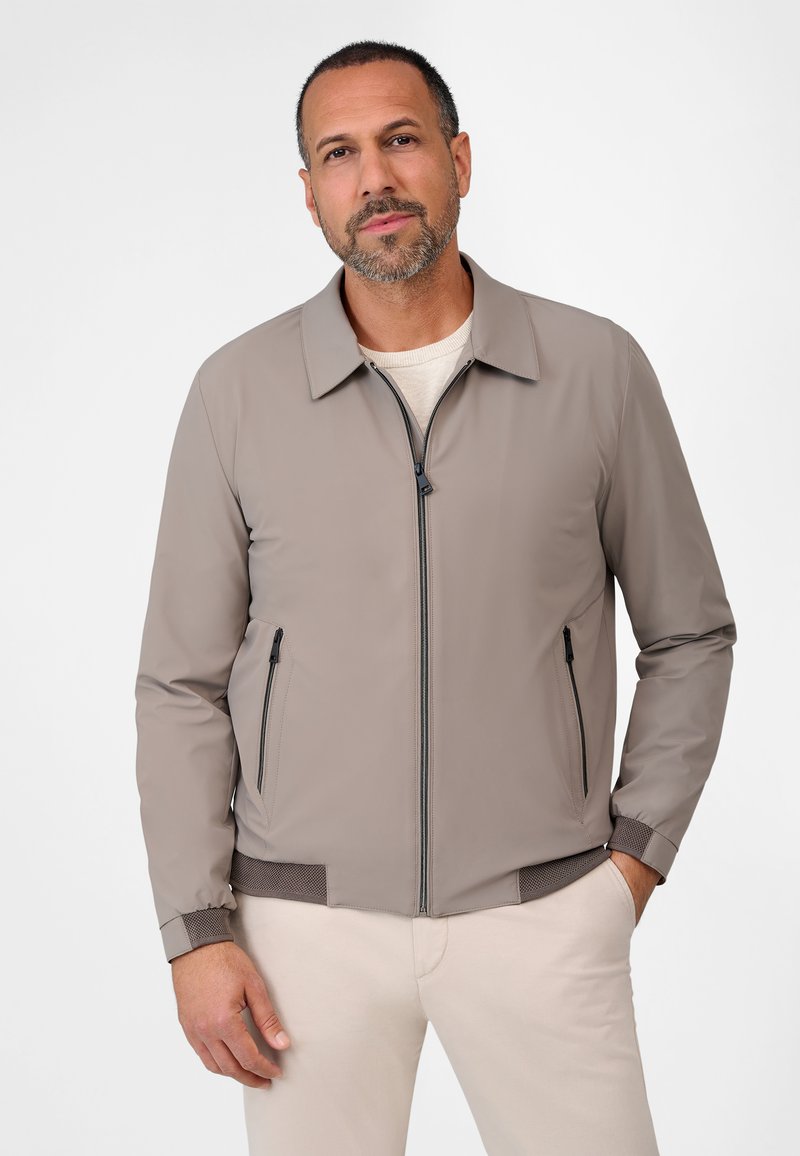 Light grey bomber jacket with a zip front, two side zip pockets, ribbed cuffs, and a textured hem. Smooth texture and sleek design.