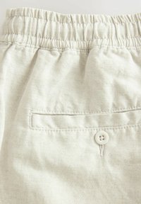 Svijetlosmeđi pamučni šorts s elastičnom trakom u struku, s stražnjim džepom koji je osiguran bijelim gumbom i vidljivim šavnim detaljima.
