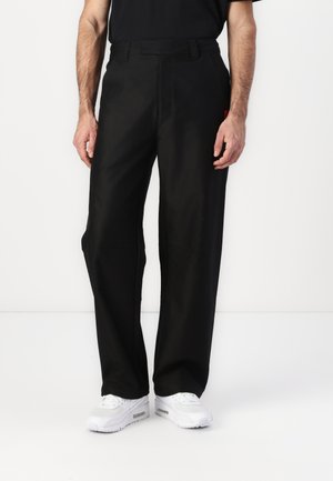 Black wide-leg pants made of smooth fabric with a straight cut. They feature a belt looped waistband and side pockets.