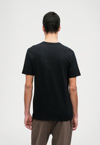 Svart, kortärmad T-shirt i bomull med klassisk rund halsringning och en mjuk yta med en ren, odekorerad design.