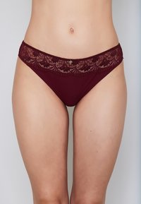 Burgundy lace-trimmed bikini briefs feature a floral pattern on the waistband, with smooth fabric and a classic cut for comfort.