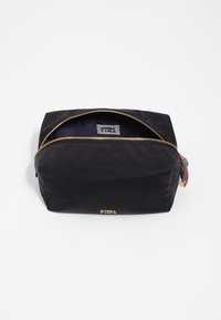 Neceser negro con una textura suave, cierre dorado y una etiqueta en su interior. Presenta una forma rectangular y un pequeño tirador de cremallera colorido.