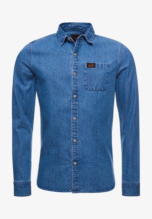Langärmliges blaues Denimhemd mit diagonalem Steppmuster, Knopfleiste vorne, Brusttasche mit Logo-Patch und klassischem Kragen.