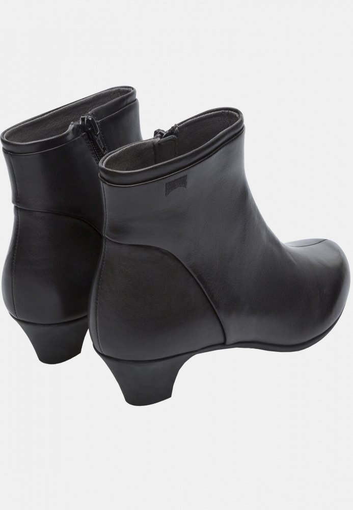 Stivali neri in pelle fino alla caviglia con punta rotonda, tacco basso e chiusura con zip; texture liscia con una leggera lucentezza e senza motivi visibili.