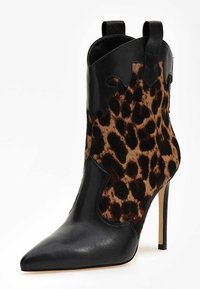 Svart läderankelboot med spetsig tå, featuring ett leopardmönstrat pänepanel och utskärningsdesign på ovandelen. Stiletto-blund.