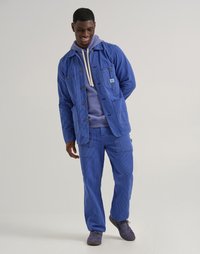 Blue corduroy jacket with matching pants, featuring front pockets and button closure. Underneath, a purple hoodie with drawstrings.
