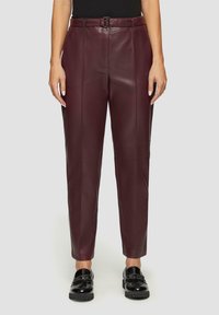 Burgundy läderbyxor med rak passform, med en bälte i midjan och slät textur. Bärs med glänsande svarta loafers.