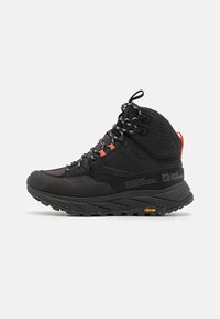 Stivale da trekking alto nero con suola robusta, lacci riflettenti, linguette arancioni e suola Vibram con marchio, mostrato su sfondo bianco.